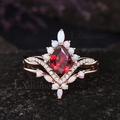 a red and white ring sitting on top of a black stone surface next to a rock