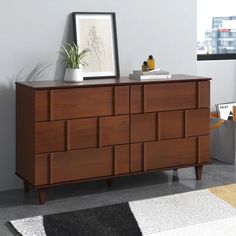 a wooden dresser sitting on top of a carpeted floor next to a white wall