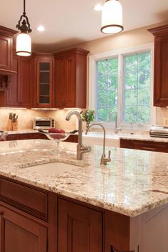 a kitchen with marble counter tops and wooden cabinets