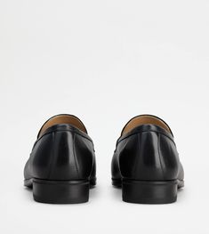 Featuring a classic penny bar, these loafers with rubber outsole come with a heel that reminds the distinctive leather manufacturing. Crafted in soft fine natural-grained leather, they come with the Tod's monogram stamped on the front. Perfect for an informal look, they also suit more formal combinations thanks to their ambivalent, functional and elegant nature. Timeless Slip-on Moccasins For Business, Timeless Business Slip-on Loafers, Timeless Slip-on Leather Shoes With Plain Toe, Timeless Slip-ons With Rubber Sole And Plain Toe, Business Loafers With Rubber Sole And Round Toe, Business Loafers With Rubber Sole, Formal Calf Leather Slip-ons With Leather Sole, Timeless Business Slip-ons With Rubber Sole, Formal Tassel Loafers With Textured Sole