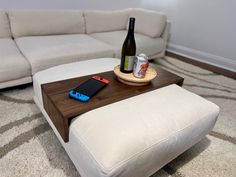 a table that has a bottle on it and a cell phone sitting on top of it