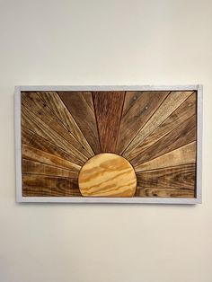 a wooden wall hanging on the side of a white wall