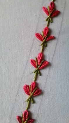 a crocheted red flower on a white surface