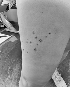 black and white photograph of stars on the back of a woman's leg,