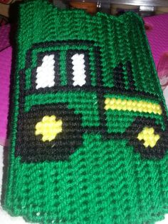 a green crocheted blanket with a bus on it