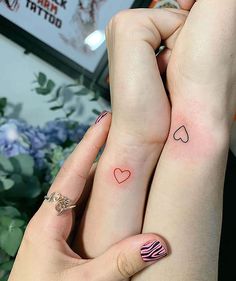 two people with matching tattoos on their hands