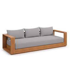 a wooden couch with four pillows on it's back and sides, in front of a white background