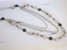 "Long Silver Chain Beaded Necklace, handmade by Ralston Originals. This long beaded necklace is made with different sizes and shapes of silver metal beads, rings, and filigree. There are 2 additional strands of silver metal chain, making the necklace 3 multi strands. The multi strands are attached to a large silver metal ring. The necklace has a lobster clasp. This beaded necklace is 40 inches long, but can be made shorter on request. This necklace is ready to send today, and it includes free sh Silver Metal Beaded Necklaces With Round Beads, Silver Beaded Necklaces With Round Beads, Elegant Silver Metal Bead Jewelry, Elegant Silver Metal Beads Jewelry, Elegant Silver Beaded Necklace, Silver Multi-strand Beaded Chain Necklace, Elegant Silver Beaded Necklace With Metal Beads, Elegant Silver Metal Bead Necklace, Elegant Silver Necklace With Metal Beads