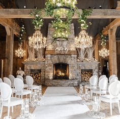 the ceremony room is decorated with white chairs and chandeliers, along with a fireplace