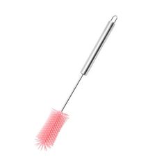 a pink brush is on the tip of a white surface and it's long, pointed