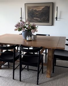 a wooden table with black chairs around it