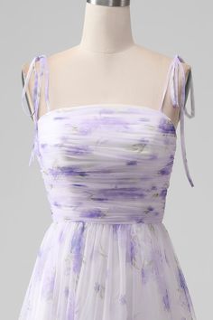 a dress on a mannequin with purple and white flowers all over it's body