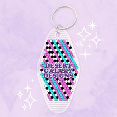 a keychain with the words desert galaxy designs on it and stars in the background