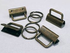 several metal buckles and rings on a white surface