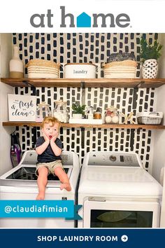 a little boy sitting on top of a washer next to a dryer in a laundry room