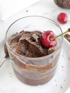 a chocolate dessert in a glass with a cherry on top