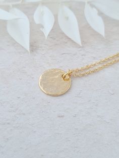 Minimalist gold plated hand hammered coin necklace. This can be worn on its own or layered. The disc is gold plated and the fine chain is gold plated. The disc measures 12mm in diameter. This item ships from the UK within 1 working day. Please note that this necklace is gold plated, therefore it must be taken off before showering, swimming, going to the gym or before applying body lotion etc. Gold Brass Minimalist Coin Necklace, Dainty Gold-plated Coin Necklace With Delicate Chain, Minimalist Tarnish-resistant Round Disc Coin Necklace, Minimalist 14k Gold-filled Coin Pendant Charm Necklace, Minimalist 14k Gold-filled Medallion Necklace, Coin Necklace, Gold Coins, Coin Pendant, Minimalist Necklace