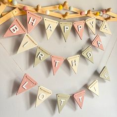 a birthday banner hanging on the wall with bunting and wooden letters that spell out happy birthday