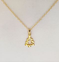 "- Gorgeous 14K Gold Plated Pewter Open-Cut Tree, or Christmas Tree, Pendant, or Necklace with 14K Gold Filled Oval Cable Chain. See Photos #1-5. - Pendant measures 15 x 24mm, or 5/8 x 1 1/4\", and drops 1 1/4\" from the Chain. - 14K Gold Plated Pinch Bail (hanger). - Stunning 14K Gold Filled Oval Cable Chain with 14K Gold Filled Lobster Claw Clasp included. See Photo #6. - Chain Length 20\" with the Clasp. - If you prefer a different Clasp we can customize for you at no cost. Clasps available i Christmas Festive Jewelry With Charms, Christmas Festive Jewelry Charms, Christmas Festive Charms Jewelry, Handmade Gold Holiday Jewelry, Handmade Gold Jewelry For Holidays, Christmas Gift Jewelry With Hallmark, Holiday Handmade Gold Jewelry, Handmade Jewelry For Holiday Celebration, Handmade Holiday Jewelry For Celebration