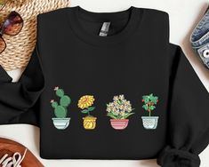 Introducing our Pot Plants Embroidered Sweatshirt, a perfect blend of style, comfort, and uniqueness designed for both men and women. This 2D Crewneck Sweatshirt is not just another ordinary clothing item; it is a statement piece that reflects your individuality and love for nature. Featuring intricate embroidery of vibrant pot plants, this sweatshirt adds a touch of botanical charm to your wardrobe. The attention to detail in the embroidery is impeccable, creating a realistic and visually stunn Casual Embroidered Crew T-shirt, Casual Long Sleeve T-shirt With Floral Embroidery, Casual Crew Neck Sweatshirt With Floral Embroidery, Black Casual Sweatshirt With Embroidered Text, Casual Sweatshirt With Floral Embroidery And Relaxed Fit, Casual Black Sweatshirt With Embroidered Text, Casual Relaxed Fit Sweatshirt With Floral Embroidery, Casual Floral Embroidery Sweatshirt With Relaxed Fit, Casual Black Embroidered Sweatshirt