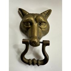 a metal fox head mounted to the side of a door knocker with two handles