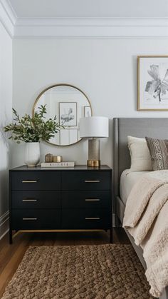 a bed room with a neatly made bed and a mirror on the wall above it