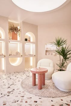 a living room with two white chairs and a round table in the middle of it