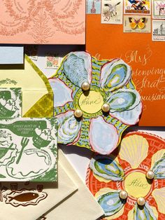 many different types of cards and envelopes on top of each other, including one with a flower