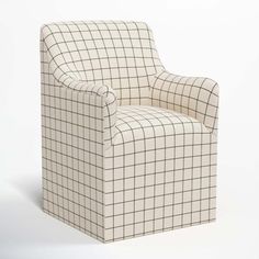 a chair that is sitting in front of a white wall with a black and white checkerboard pattern on it