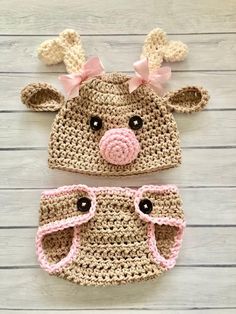 two crocheted hats with pink bows on the ears and one has a nose