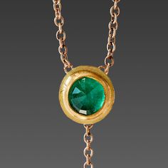 A brilliant rose cut emerald shines within a warm 22k gold wrapping, backed in solid gold, and stationed on a delicate 16 inch, 14k gold chain. The luminous gem is accented with a tiny 22k gold drop that hangs 1 inch below creating a lovely movement. A truly magical piece. Emerald pendant measures approximately 1/4 inch in diameter. Matte finish. This piece will be made to order, and will ship within 10-14 business days. If you need it sooner, use the Notes section on the order form to request a Gold Emerald Necklace With Adjustable Chain For Formal Events, Gold Emerald Necklace With Adjustable Chain For Formal Occasions, Gold Emerald Necklace With Delicate Chain, Fine Jewelry, Fine Jewelry Gold Emerald Necklace With Delicate Chain, Gold Emerald Necklace With Adjustable Chain, Formal Gold Emerald Necklace With Round Pendant, Elegant Gold Briolette Emerald Necklace, Emerald Necklace With Delicate Yellow Gold Chain, Gold Emerald Pendant Birthstone Necklace