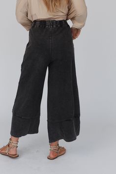 Yes, you need these pants. The most effortless lounge pant there is...and it has pockets! wide cropped leg style perfect for all heights, drawstring waist for the perfect fit, and detailed stitching to give it that extra boho flare...so good you may need two! *Due to lighting and differences in monitors, actual colors may vary slightly from what appears online Model is 5'8" and wearing a size Small. Approximate measurements are as follows: SMALL: Waist: 28", Inseam: 25", Length: 36" MEDIUM: Wais Comfortable Black Wide-leg Harem Pants, Black Relaxed Fit Capri Pants, Casual Black Bottoms, Wide Leg Capris With Pockets For Loungewear, Washed Black Wide-leg Pants For Fall, Black Wide Leg Pants With Frayed Hem, Wide-leg Capris With Elastic Waistband For Loungewear, Washed Black Wide Leg Bottoms With Frayed Hem, Wide Leg Capris With Elastic Waistband For Loungewear