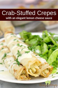 crab - stuffed crepes with an elegant lemon cheese sauce on a white plate