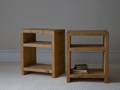 two small wooden shelves sitting next to each other on top of a carpeted floor