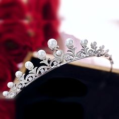 Adorned with iridescent pearls and intricately faceted clear cubic zirconia that work their way across the band in a swirly pattern, this delicate tiara can complete the most sophisticated of bridal looks. Cast in lightweight alloy and rhodium plated for a flawless finish, the headband measures 1.25" (approx. 3cm) at the tallest point and 5.5" (approx. 14cm)in diameter. Two small loops at each end make it easy to attach to your hair with bobby pins. Its incredible sparkle coordinates with any co Delicate Tiara, Tiara With Pearls, Swirly Pattern, Wedding Boards, Iridescent Pearl, Hair Accessories Pearl, Wedding Tiara, Colored Wedding Dresses, Bridal Tiara