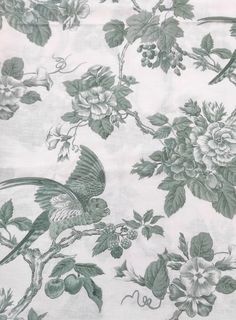 a green and white floral print fabric with birds on it's back end,