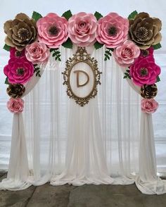 the backdrop is decorated with paper flowers and a monogrammed d on it's side