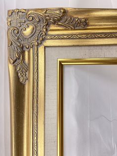 an ornate gold frame on a white wall