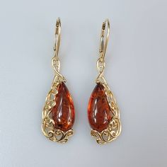 Big hanging Amber earrings. Made off Gold plated sterling silver 925 (Gold colour). With silver hallmarks. Big brown cognac Amber. Very cute and elegant. Each pair amber stone color ia slightly different due to an amber is real gemstone. Lever back closure. Length 5 cm. Width 1,2 cm. Weight 6,3 gr. This item was made of natural Baltic Amber. All the amber used in my jewelry is collected in my home country Lithuania. I sell only genuine, real, not pressed, authentic, natural Baltic Amber. Item ma Amber And Gold Jewelry, Cheap Amber Dangle Jewelry, Amber Teardrop Pierced Jewelry, Hypoallergenic Amber Teardrop Jewelry, Classic Teardrop Pierced Earrings, Classic Long Drop Earrings As Gift, Classic Long Drop Earrings For Gifts, Hypoallergenic Long Drop Earrings For Anniversary, Classic Amber Earrings For Gift