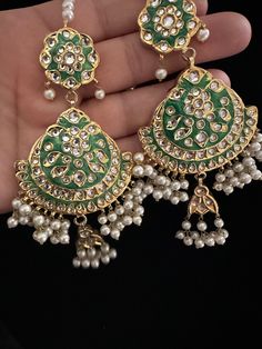 It's time you level up your jewelry box! Add in some extra ordinary piece in your collection! This majestic 22 KT gold plated lock thappa kundan chandbali earrings with beautiful combination of hand painted meena work and kundan pearl work earrings with sahara. In stock and ready to ship. Color : green Note :Color, shades, texture displayed may slightly vary from the actual product due to digital image limitations. We request you to consider these minor variations. Please expect the possibility Green Kundan Earrings With Stone Work, Handmade Green Chandbali Bridal Earrings, Green Kundan Bridal Earrings With Tilla Detail, Green Kundan Bridal Earrings With Tilla, Eid Chandbali Bridal Earrings With Mirror Work, Eid Bridal Chandbali Earrings With Mirror Work, Festive Green Chandelier Earrings With Stone Work, Green Kundan Chandbali Chandelier Earrings, Green Kundan Drop Dangler Earrings