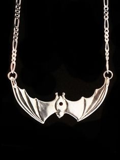 "This solid sterling silver Bat pendant would love to hang around your neck. It's wing span is 2 1/4\" across. A 16\" figaro chain is attached to both wing tips and is included in the price of this piece making the total length of the pendant just over 18\". A 5mm x 7mm gemstone is bezel set in the back of the bat. Take flight with one tonight. Please select your desired gemstone in the dropdown options menu. You may choose between a Blue Topaz, Citrine, Amethyst, Peridot, Black Onyx or Mozambiq Bat Pendant, Bat Jewelry, Bat Necklace, Halloween Necklace, Figaro Chains, Figaro Chain, Gothic Jewelry, Bat Wings, Necklace Silver