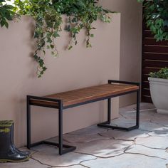 a wooden bench sitting next to a plant