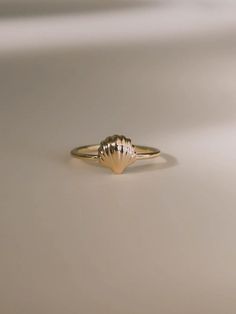 Inspired by Venus, the goddess of love, to celebrate love and relationships. First handcrafted from wax and then cast in gold, this ring's design echoes the delicate curves of a seashell, capturing the essence of Venus’s oceanic origins. Each piece honors the beauty and harmony of nature, making it a perfect symbol of romance and new beginnings. A must-have for your jewelry collection. Shell measures approximately 8 mm. Band thickness is 1.3 mm. Shiny finish or matte finish. Made with 10K solid yellow or white gold. Tiny Recycled Gold Rings, Elegant Shell-shaped Brass Jewelry, Shell-shaped Gold Jewelry For Wedding, Dainty Hand-forged Rings In Recycled Gold, Hand Forged Dainty Rings In Recycled Gold, Hand Forged Recycled Gold Dainty Rings, Gold Shell-shaped Ring For Gift, Elegant Shell-shaped Ring For Gifts, Gold Shell-shaped Gift Ring