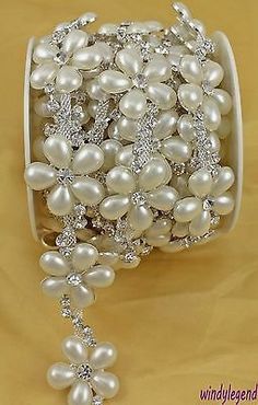 a white ribbon with pearls and crystals on it