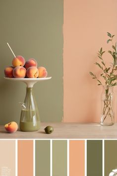 peaches and green olives are on a tray in front of a pink wall