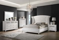 a bedroom with black walls, white furniture and a chandelier hanging from the ceiling