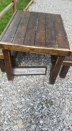 a wooden bench sitting on top of gravel