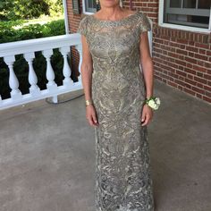 a woman in a dress standing on a porch