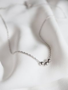 A simple and minimal piece, this tiny bead necklace is sure to become an everyday staple for layering.  3 little satin finish round beads slide freely along delicate chainMATERIALStarnish resistant rhodium silver filled or gold filled charm & chainDIMENSIONS40.6cm (16") plus 2" extender chain, each bead measures 4mm (5/32") diameter◊ Matching sphere jewelry: https://www.etsy.com/shop/kindlingandco/search?search_query=ball◊ More dainty charm necklaces: https://www.etsy.com/shop/kindlingandco? Minimalist Everyday Jewelry With Ball Chain, Everyday Minimalist Jewelry With Ball Chain, Everyday Minimalist Ball Chain Jewelry, Minimalist Necklace With Ball Chain And Round Beads, Minimalist Jewelry With Satellite Chain, Minimalist Sterling Silver Necklace With Round Beads, Tiny Bead Necklace, Necklaces Personalized, 3 Daughters