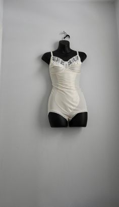 🌹Description Elegant, one piece stretchy ivory coloured lingerie bodysuit. Garnet has sot, seamed cups with lace at the top edges. Double seamed cups with no underwire. Low back with elasticated edge, adjustable straps. Leg openings are edged in stretch lace, crotch closes with two rows of hooks. Fabulous lingerie in true vintage loveliness... 🌹 Material Sumptuous, silky blend of polyamide, polyester, and cotton 🌹Label "Barbara Paris" Made in France  FR 100 Eur 85 INT 38 C cup 🌹 Condition Ex Fitted White Bodysuit With Built-in Bra, Underbust Shapewear With Boned Bodice, Lace Shapewear Bodysuit Fitted, Fitted Lace Shapewear Bodysuit, Lace Shapewear Bodysuit With Lined Body, Elegant Fitted Lace Shapewear, Underbust Shapewear Corset With Lined Body, White Shapewear Bodysuit With Lined Body, Elegant Fitted Shapewear With Lace Trim